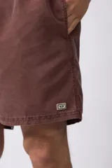 Short de baño de corte relajado en color gris azulado con efecto lavado. Cuenta con cintura elastizada con cordón ajustable, bolsillos laterales y una pequeña etiqueta decorativa en el ruedo.