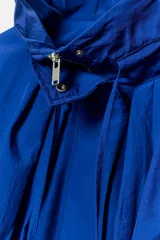 Cazadora bomber de cuello subido ajustable con cordones, manga larga con puños elásticos y cierre frontal con cremallera y botones a presión ocultos. Presenta bolsillos delanteros y un diseño holgado.