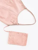Bolso tipo hobo confeccionado en cuero vacuno con efecto rugoso, de color negro, con manija larga de hombro y ribetes en cuero liso. Incluye un llavero colgante de cuero con la marca grabada.