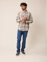 Camisa de manga larga con cuello abotonado y cierre frontal de botones. Presenta un diseño de cuadros en tonos beige, blanco y azul con líneas finas en rojo.