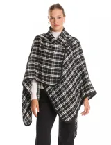 Ruana tejida con diseño de cuadros en blanco y negro, con borde ribeteado y cierre frontal tipo trenca con detalle de cuero sintético.