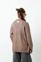 Polera marrón de tejido de punto con cuello alto y corte oversized.