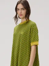 Vestido corto de algodón con estampa geométrica en tonos verde y amarillo, cuello redondo y mangas cortas con puños en color contrastante.
