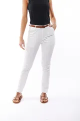 Pantalón blanco de corte recto, con bolsillos laterales y traseros. Se ajusta a la cintura con cinturón de cuero marrón.