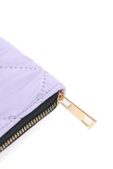 Billetera larga color lila con diseño acolchado y cierre perimetral con cremallera dorada.