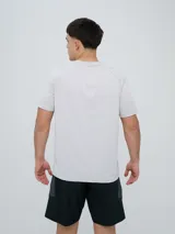 Remera deportiva Umbro modelo Axis, de manga corta, color gris claro con textura perforada transpirable y logo negro de la marca en el pecho.