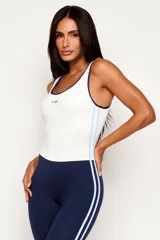Monopieza deportiva color azul marino y blanco, con efecto bicolor que simula la combinación de una musculosa y calzas. Presenta dos tiras laterales en celeste y breteles medios.