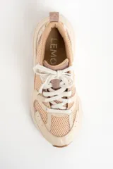 Zapatilla deportiva de mujer con plataforma gruesa, combinando paneles de malla transpirable color beige claro y superposiciones en tonos rosa viejo y crema. Cordones blancos y suela de goma color caramelo.