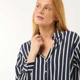Blusa de corte fluido y holgado con estampado de rayas verticales en azul marino y blanco. Presenta cuello camisero clásico, cierre frontal con botones y mangas largas con puños abotonados.