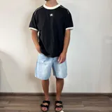 Remera de manga corta color crema con cuello redondo y ribetes en color gris oscuro. Presenta un pequeño logo bordado en el pecho con la palabra "SANTOS".