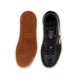 Championes Puma modelo Palermo LTH, con diseño de perfil bajo, cuerpo de cuero blanco, detalles en gamuza gris y franja lateral en color lila. Cuenta con suela de goma color caramelo y logo dorado en el lateral.