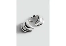 Aros tipo argollas pequeñas con diseño abullonado y superficie lisa brillante.