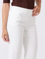 Pantalón sastrero de corte slim, color blanco, con pretina anatómica y panel interno modelador. Presenta bolsillos laterales tipo ojal, bolsillos traseros simulados y nervadura vertical marcada en el frente.