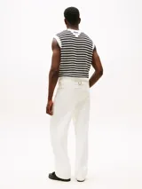 Pantalón jean blanco de corte amplio y pierna recta, con cintura ajustable en la parte trasera. Presenta cierre de cremallera con botón, dos bolsillos delanteros de parche y dos bolsillos traseros ribeteados. Detalles distintivos de la colección APXGP.