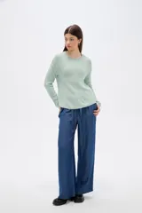 Sweater de tejido de punto fino en color blanco, con cuello redondo a la base y mangas largas de corte holgado.