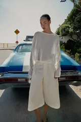 Bermuda larga cargo color blanco, con pinzas delanteras, bolsillos laterales de plastrón con solapa, cierre frontal con cremallera y botón.