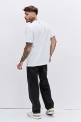 Pantalón de jean corte relaxed, color negro, con diseño de cinco bolsillos y cierre frontal con botón y cremallera.