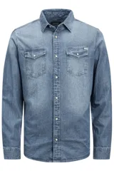 Camisa de denim celeste de manga larga, con cuello clásico, cierre frontal con botones a presión y dos bolsillos con solapa abotonada en el pecho.