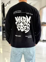 Buzo oversize color beige, con diseño gráfico en la espalda con el texto 'Warm Vibes' en tono marrón y tipografía psicodélica, acompañado de frases secundarias.