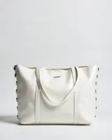 Cartera tipo tote de símil cuero blanco, con dos asas de mano y detalles de herrajes plateados en los laterales.