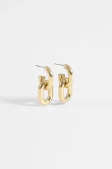 Aros tipo argolla con diseño de doble eslabón entrelazado, confeccionados en acero quirúrgico con acabado dorado.