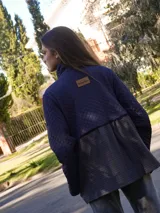 Campera con cierre frontal, de corte entallado, con parte superior acolchada en color negro y parte inferior en tweed gris.