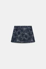 Falda pantalón corta de denim azul oscuro con bordados de flores en hilo metalizado plateado y detalles de lentejuelas.