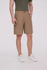 Bermuda de corte recto y diseño minimalista, confeccionada en tejido técnico de poliéster. Presenta cintura elástica con cierre de botón frontal, bolsillos laterales y un bolsillo pequeño adicional en el lateral izquierdo.