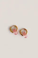 Aros argollas dorados con dije de piedra en tono rosado.