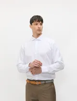 Camisa de vestir blanca de manga larga, con cuello clásico y cierre frontal de botones.