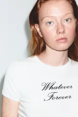 Camiseta de algodón color rosa vibrante, corte regular fit, cuello redondo y manga corta. Presenta un texto estampado en negro con tipografía cursiva que dice "Made of Stardust".