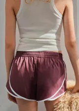Short deportivo de corte retro, color bordó con ribetes blancos en los bordes y cintura elástica.