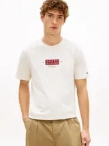 Remera de corte regular y cuello redondo de la marca Tommy Hilfiger, confeccionada en algodón de color blanco. Presenta un diseño gráfico en el pecho con el logo NYC y un pequeño logo bordado en la manga.