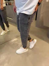 Jean de corte slouchy en color gris con efecto acid wash, con bolsillos laterales y traseros, y botamangas con dobladillo.