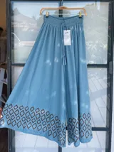 Pantalón palazzo celeste con cintura elastizada y cordón ajustable. Estampado de figuras geométricas en el ruedo.