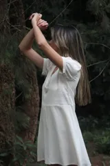 Vestido corto color blanco hueso, de lino con mezcla, corte evasé, cuello en V y botones de nácar.