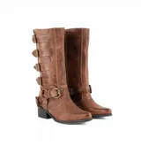 Bota de caña alta color marrón, confeccionada en cuero vacuno. Presenta un diseño estilo biker con múltiples tiras horizontales con hebillas metálicas, una correa adicional con argolla en el tobillo y un taco cuadrado de madera.
