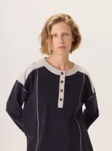 Buzo de manga larga con diseño color block. Cuerpo principal color camel, sección central de la espalda color azul marino liso y hombros con tejido de lana texturado en tonos azules. Posee un parche de cuero marrón con el logo grabado en la espalda.