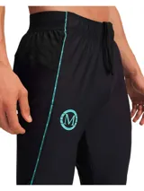Pantalón deportivo negro Under Armour Mansory Challenger, con detalles en celeste, logo de Under Armour y logo de Mansory. Corte ajustado y tecnología que absorbe el sudor. Ideal para entrenamiento y uso casual.