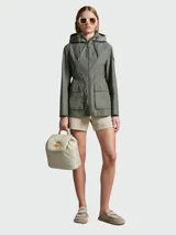 Campera verde militar con capucha, cierre frontal con cremallera, bolsillos con solapa y cordón ajustable en la cintura.