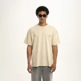 Remera color arena con cuello redondo y estampado pequeño en el pecho.