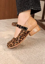 Zapatos de taco ancho con diseño destalonado y pulsera con hebilla en el empeine. Presentan una combinación de cuero con estampado animal print de leopardo, tono camel y detalles en negro charol.