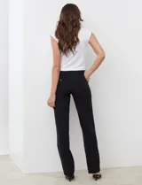Pantalón de corte recto color negro, con tiro medio-alto, presillas para cinturón, bolsillos laterales y bolsillos traseros de ojal con botón.