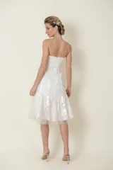 Vestido blanco strapless de tul drapeado con cintas de satén en la falda y corsé de encaje bordado.