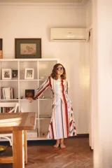 Camisa negra de popelina, con diseño cruzado y cordones laterales estilo corsé, cuello clásico, mangas abullonadas y gran estampado floral en el frente.