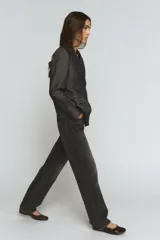 Blazer de mujer color gris oscuro, con efecto denim o tejido texturizado. Presenta cuello solapa de muescas, hombreras, bolsillos con solapa en el delantero y cierre frontal de dos botones oscuros.