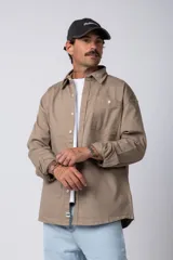 Camisa de manga larga estilo sobrecamisa, color negro, con corte oversize, cuello clásico, cierre frontal con botones y bolsillo frontal en el pecho.