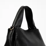 Bandolera negra de cuero sintético con correa ajustable y herrajes dorados.