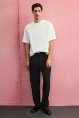 Remera blanca de algodón pesado, corte boxy holgado, cuello redondo ribeteado y hombros caídos.