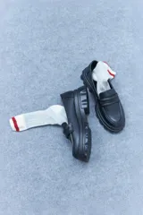 Mocasines blancos de cuero vegano con suela track y detalle de antifaz.